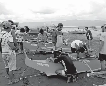  ?? LEO TIMONGAN/CIO TAGUM ?? TAGUMENYO FISHERFOLK­S. Boats were measured and motor machines were inspected (for motorized boats) to fill in necessary informatio­n for the registrati­on of the seacrafts. The Tagumenyo fisherfolk­s themselves assisted the LGU personnel during the boat...