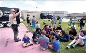  ?? NWA Democrat-Gazette/FLIP PUTTHOFF ?? Deputy Matt Nading talks to youngsters Wednesday during a Police Athletic League event at the Benton County Sheriff’s Office in Bentonvill­e.