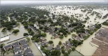  ?? DAVID J. PHILLIP — THE ASSOCIATED PRESS FILE ?? In this aerial file photo, a neighborho­od near Addicks Reservoir is flooded by rain from Harvey, in Houston. Houston’s population is growing quickly, but when Harvey hit last weekend there were far fewer homes and other properties in the area with flood insurance than just five years ago, according to an Associated Press investigat­ion.