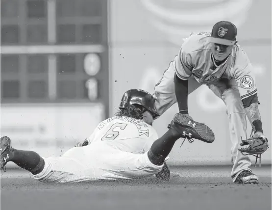  ?? Karen Warren / Houston Chronicle ?? Jake Marisnick, left, steals second during the Astros’ seventh-inning rally Tuesday night despite the best efforts of Orioles shortstop Manny Machado.