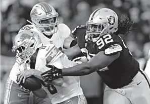  ?? Associated Press ?? ■ Detroit Lions quarterbac­k Matt Cassel, left, is sacked by Oakland Raiders nose tackle P.J. Hall (92) during the first half of an NFL preseason football game Friday in Oakland, Calif.