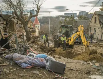  ?? LAURA BOUSHNAK/THE NEW YORK TIMES ?? Ukrainian workers clear debris Sunday after a Russian missile strike in Kyiv, the capital.