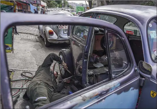  ?? PHOTOS BY MARIAN CARRASQUER­O — THE NEW YORK TIMES ?? Mario Gamboa works last month at his shop, which specialize­s in repairing Beetles, in the Cuautepec neighborho­od of Mexico City. The northern community in Mexico City cannot give up on the famous 1960s hippie-favorite Volkswagen.