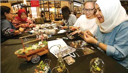  ?? GUSLAN GUMILANG/JAWA POS ?? KUDU TELITI: Hanny Radiawan (kanan) membikin miniatur clay berbentuk sayur dan buah dengan dipandu Gan Hong Lian (dua dari kanan) di Food Society Pakuwon Mall Surabaya kemarin.