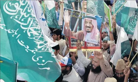  ?? Arif Ali AFP/Getty Images ?? PROTESTERS IN LAHORE, Pakistan, hold up pictures of Saudi King Salman to show their support for his air campaign in Yemen. Some of Saudi Arabia’s Sunni Muslim allies are wary of the war, including Pakistan, whose lawmakers voted to stay out of the conf...