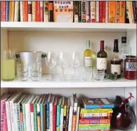  ?? AP/LAURA AGRA/KATIE WORKMAN ?? This November 2015 photo provided by Katie Workman shows a temporary bar for a party being set up in a bookcase in New York. Making the most of different areas of your home is very helpful when you have a big group over.