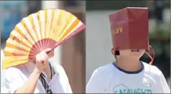  ??  ?? 重慶21日氣溫高升，市民將摺扇、購物袋頂上頭遮擋刺眼­的陽光。 （中新社）