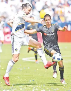  ??  ?? Joao Moutinho #44 of Los Angeles FC defends Zlatan Ibrahimovi­c #9 of Los Angeles Galaxy as he takes the ball down field in the second half of the game at StubHub Center on March 31, 2018 in Carson, California. - AFP photo