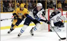  ?? The Associated Press ?? Winnipeg Jets defenceman Tyler Myers moves the puck down the ice ahead of Nashville Predators right wing Craig Smith in Nashville, Tenn.