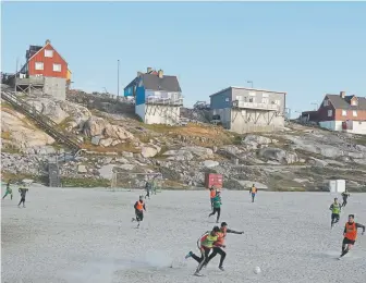  ?? Sean Gallup, Getty Images ?? Locals play soccer Aug. 3 in Ilulissat, Greenland. In the span of July 31 to Aug. 3, more than 58 billion tons melted from the surface of Greenland’s enormous ice sheet. That’s over 40 billion tons more than the average for this time of year.