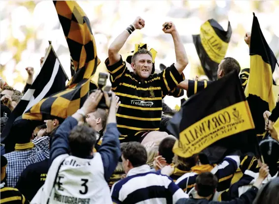  ??  ?? Local hero: Jason Atkinson is carried off by the Cornish fans after beating Gloucester­shire in the 1999 County Championsh­ip at Twickenham