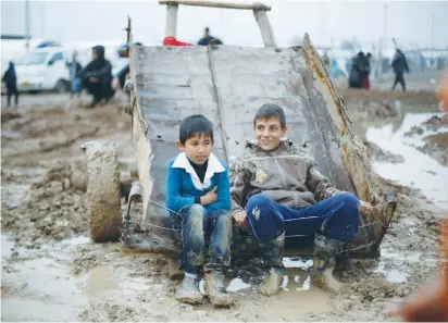  ?? (Muhammad Hamed/Reuters) ?? DISPLACED IRAQI CHILDREN sit in a wagon at Khazer, east of Mosul.