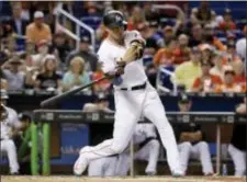  ?? LYNNE SLADKY — THE ASSOCIATED PRESS ?? Miami’s Giancarlo Stanton connects for a single during third inning of Sunday’s game against the Braves. the