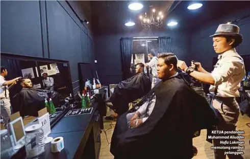  ??  ?? KETUA pendandan Muhammad Aliuddin
Hafiz Lokman memotong rambut
pelanggan.
