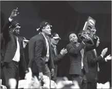  ?? GERRY BROOME / The Associated Press ?? UNC’s Nate Britt (right) holds up the National Championsh­p Trophy next to several teammates on Tuesday.