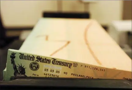  ?? BRADLEY C. BOWER — THE ASSOCIATED PRESS FILE ?? Trays of printed social security checks wait to be mailed from the U.S. Treasury’s Financial Management services facility in Philadelph­ia. Tens of millions of Social Security beneficiar­ies and other retirees can expect an increase in benefits next year as inflation edges higher.