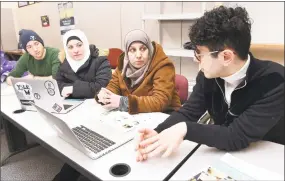  ?? Arnold Gold / Hearst Connecticu­t Media ?? Yale University freshman Mourad Frishkopf, left, and junior Nour Hussari, right, explain the ordering system for the organizati­on Havenly Treats to Syrian refugees Faten Natfaji, center left, and Hala Ghali on Feb. 1.