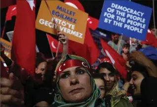  ?? HUSSEIN MALLA, THE ASSOCIATED PRESS ?? Supporters of Turkish President Recep Tayyip Erdogan hold placards and wave their national flags during a pro-government rally at Kizilay main square, in Ankara, Turkey, on Wednesday.