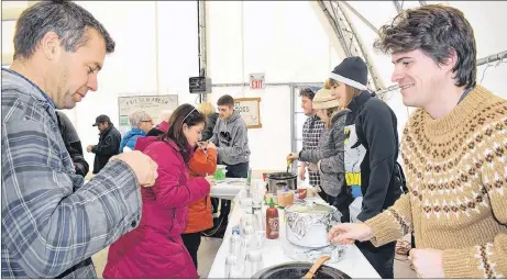  ?? KEVIN ADSHADE/THE NEWS ?? Brendan Ahern, a reporter with The News, hands out a chili sample on Saturday.