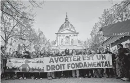  ?? KIRAN RIDLEY AFP/Getty Images/TNS ?? Protesters hold a banner that says, ‘Women decide, Abortion is a fundamenta­l right,’ in Paris on Feb. 28.