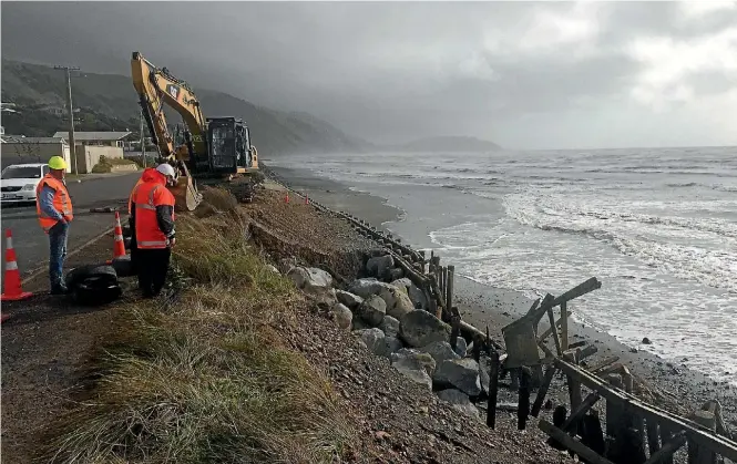  ?? PHOTO: JOEL MAXWELL/FAIRFAX NZ ?? Contractor­s work to fill a breach in the wall protecting a walking path and The Parade, south of Ocean Rd in Paekakarik­i.