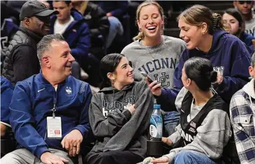  ?? Jessica Hill/Associated Press ?? Social media personalit­ies Marc D’Amelio, left, and daughters Charli D’Amelio, center, and Dixie D’Amelio, right, pose for photos with UConn fans on Feb. 16, 2022 at Gampel Pavilion in Storrs.