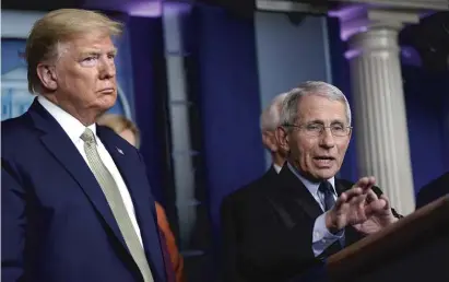  ?? DREW ANGERER/GETTY IMAGES ?? President Donald Trump looks on Tuesday as National Institute of Allergy and Infectious Diseases Director Dr. Anthony Fauci speaks about the coronaviru­s outbreak at the White House.