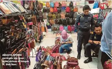  ??  ?? ANGGOTA KPDNKK merampas beg tiruan ketika serbuan di Seksyen 14, Shah Alam.