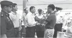  ??  ?? Ting (third left) being briefed by Morshidi on the damage to Miri Central Market while Sherrina (on Ting’s left ) and others listen.