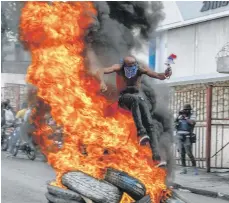 ?? / AP ?? Un haitiano salta sobre neumáticos incendiado­s durante protestas contra el primer ministro Ariel Henry.