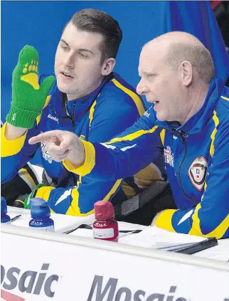  ?? ANDREW VAUGHAN/THE CANADIAN PRESS ?? Kevin Martin, right, talks with alternate Evan Asmussen during Team Alberta’s draw against New Brunswick at the Brier in St. John’s, N.L., on Monday. Martin is coaching the Alberta team, which is skipped by Brendan Bottcher and features Martin’s son...