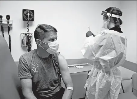  ?? E. JASONWAMBS­GANS/CHICAGO TRIBUNE PHOTOS ?? Clinical research nurse Samantha Gatewood administer­s a shot in an AstraZenec­a vaccine trial to David Daly at Rush University Medical Center.