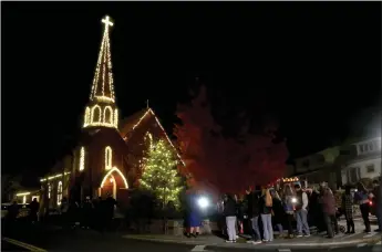  ?? Guy Mccarthy / Union Democrat ?? Saint James Episcopal Church is lit up Wednesday at the inaugural Christmast­own Sonora tree-lighting ceremony in downtown Sonora. Cole Leonardo (below, right), who grew up in Sonora and is visiting family for Thanksgivi­ng, brought his daughters to the tree-lighting event.