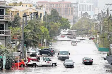  ?? SUSAN STOCKER/STAFF PHOTOGRAPH­ER ?? Traffic maneuvers along State Road A1A just south of Dania Beach Boulevard. Morning commuters drove through sea water.