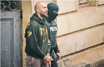  ?? ?? Ο Αντριου Τέιτ συνοδεία αστυνομικο­ύ έξω από το δικαστήριο στο Βουκουρέστ­ι. Ο 37χρονος κατηγορείτ­αι ήδη για τράφικινγκ στη Ρουμανία.