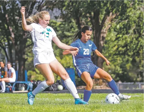  ?? GABRIELA CAMPOS/THE NEW MEXICAN ?? St. Michael’s Grace Sandoval, right, battles Los Alamos’ Dalia Drew for control of the ball during Tuesday’s game at Christian Brothers Athletic Complex. The Lady Horsemen won, 5-3.