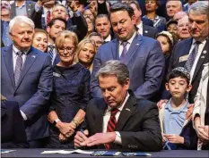  ?? ARVIN TEMKAR /ARVIN.TEMKAR@AJC.COM ?? Gov. Brian Kemp signs the antisemiti­sm bill targeting criminal acts against Jewish people on Wednesday.