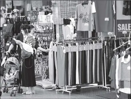  ??  ?? Shoppers look around goods at a shop in Tokyo, Japan.