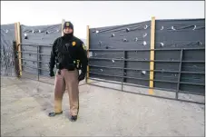  ??  ?? A Navajo Nation Police officer guards the entrance to a cannabis operation on Farm Road in Shiprock. All of the farms that had been raided were guarded by 24-hour security.