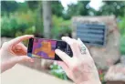  ?? NATHAN J. FISH/THE OKLAHOMAN ?? Sarah Terry-Cobo shows a thermal imaging reading of the natural and the built environmen­t Saturday around the Will Rogers Senior Center in Oklahoma City.