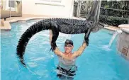  ?? Paul Bedard / Associated Press ?? Paul Bedard, a local trapper, raises an 8-foot alligator over his head at a home in Parkland, Fla.