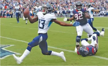  ?? AP PHOTO/MARK ZALESKI ?? Tennessee Titans wide receiver Taywan Taylor scores on an 18-yard touchdown pass from Blaine Gabbert with Houston Texans defensive tackle Brandon Dunn (92) trailing during Sunday’s game in Nashville. Taylor had three catches for 32 yards as the Titans won 20-17.