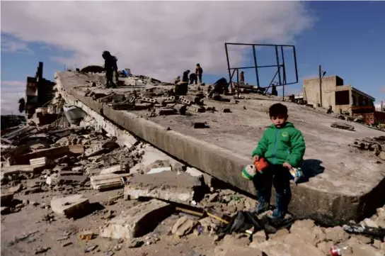  ?? BAKR ALKASEM/AFP VIA GETTY IMAGES ?? A Syrian child sat on a collapsed building in the town of Azaz on the border with Turkey on Tuesday.