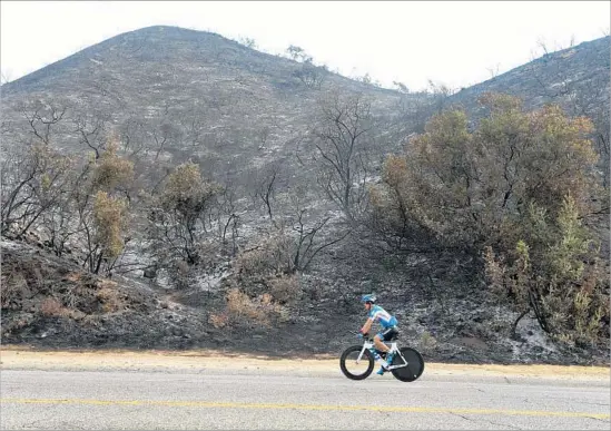  ?? Michael Owen Baker For The Times ?? THE LA TUNA fire, which has raged since Friday, is considered the largest blaze by acreage in L.A.’s history. Above, Luis Ramirez rides past charred hills in Burbank.