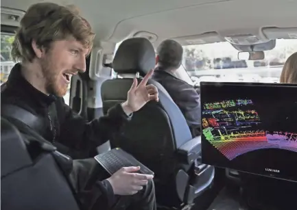  ??  ?? Luminar CEO Austin Russell looks at a 3-D lidar map on a demonstrat­ion drive in San Francisco. Smaller versions of laser sensors that sit atop self-driving cars are coming to mainstream vehicles. BEN MARGOT / AP