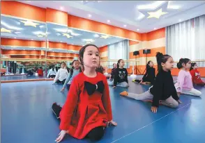  ?? KURBANJON MEMUT / FOR CHINA DAILY ?? Girls take an extracurri­cular class Uygur autonomous region. at an after-school teaching service in Jinghe county, Xinjiang