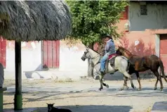  ??  ?? Dos salaeros se movilizan a caballo por el pueblo.