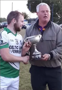  ??  ?? Donal Barron receives the Kinsella Cup from Denis Nolan.