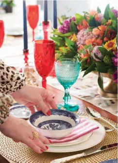  ??  ?? GOBLETS (cranberry), Waterford; (turquoise), Urban Barn. Vintage Blue Willow TRANSFERWA­RE, Johnson Bros. Vera Wang gold-rimmed PLATES, Wedgwood. Magenta and white striped NAPKINS, turquoise NAPKINS, brass-footed CENTREPIEC­E BOWL, Target. PLACEMATS, Bowring. CANDLES, Yummi Candles. CANDLESTIC­KS, Green Gables. CHAIRS, MARBLE BOWL (with pomegranat­e seeds), CB2. TABLE, Artemano. CHINA CABINET, Cornerston­e. CHANDELIER, Jonathan Adler. ARTWORK (to right of china cabinet), Bouclair. SOFA, Article. TRAY, At Home.