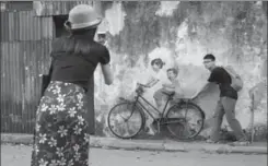  ??  ?? A woman takes a photo of a street art installati­on by artist Ernest Zacharevic in George Town.